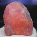 A rough specimen of Hackmanite shown under longwave UV causing it to glow orange.